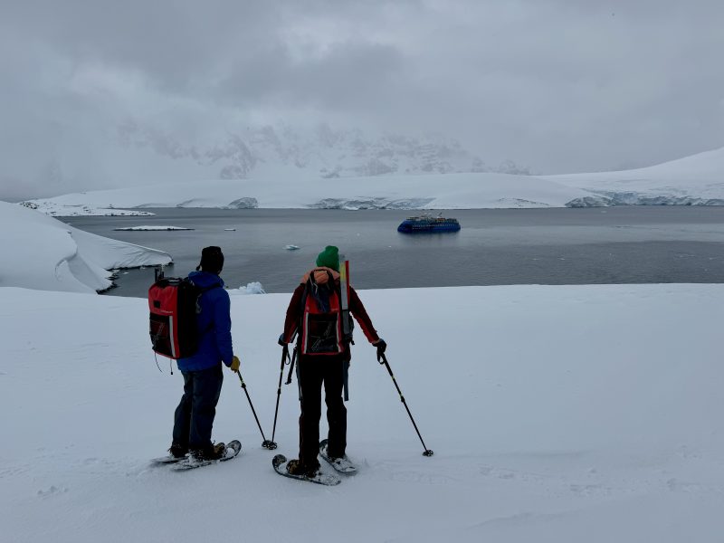 Dos senderistas con raquetas de nieve en la Antártida.