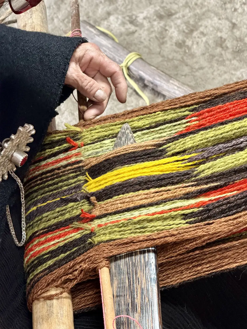 Mujer indígena tejiendo en Ecuador.