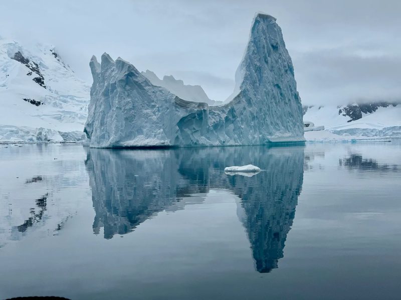 Iceberg reflejado en las aguas de la Antártida en un itinerario por la Península