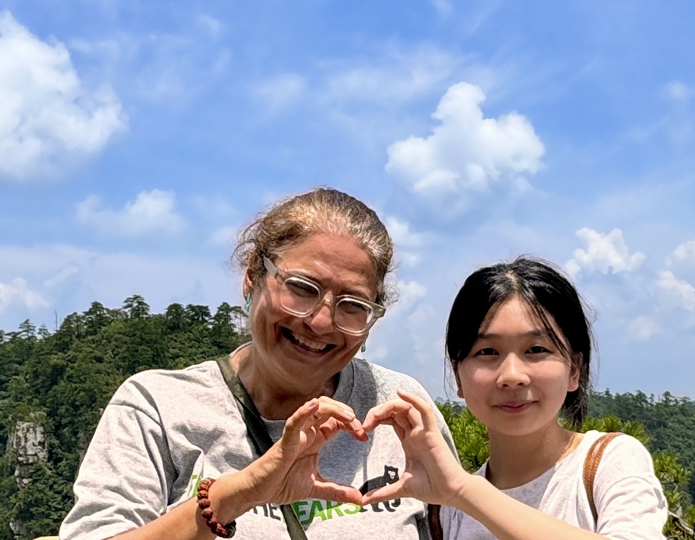 Viajera española con una joven local haciendo un corazón con las manos en Zhangjiajie, China